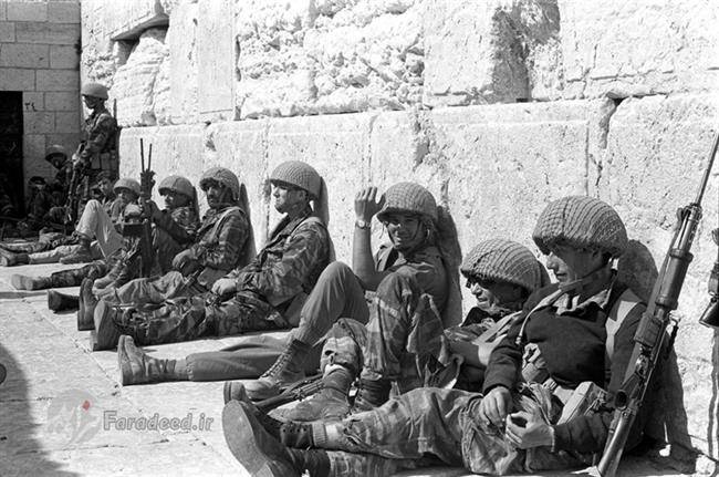 سربازان اسرائیلی پس از پیروزی در جنگ، در حالت استراحت پای دیوار ندبه نشته اند.