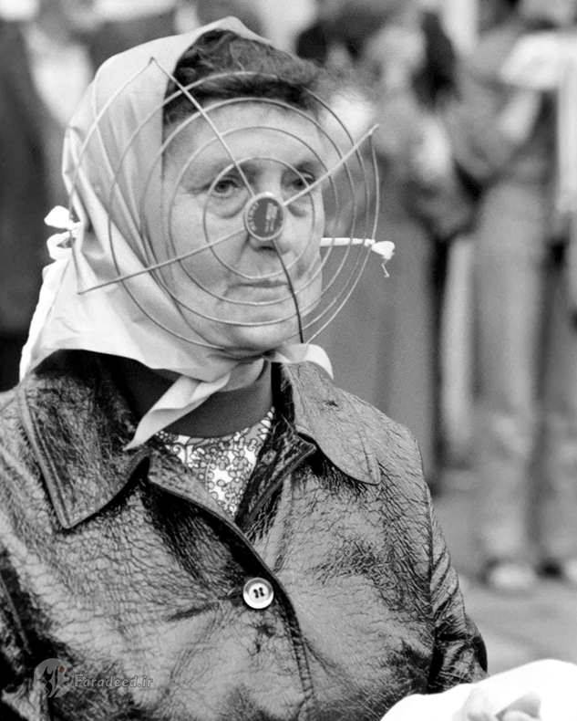 زنی که برای خردید روزانه از خانه خارج شده است. او برای در امان ماندن از اجسامی که در خیابان پرتاب می شدند، یک ماسک مخصوص فلزی به صورت خود زده بود.