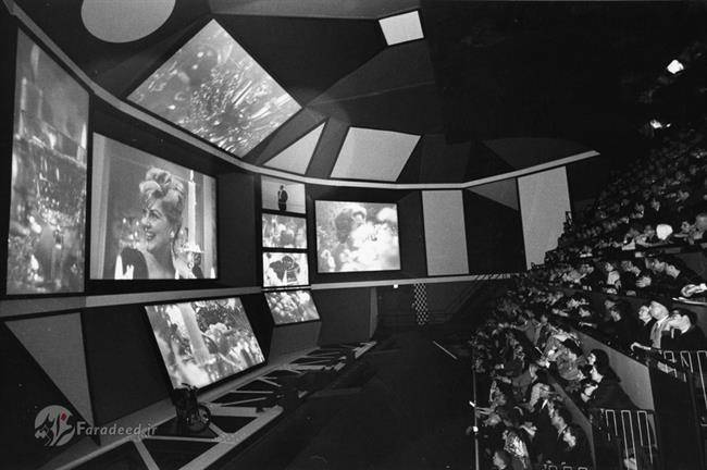 مخاطبان در حال تماشای یک ارائه چند نمایشگری در غرفه آی بی ام در جریان نمایشگاه جهانی 1964-1965 در نیویورک