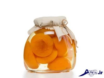 ریختن کمپوت هلو در درون بطری شیشه ای
