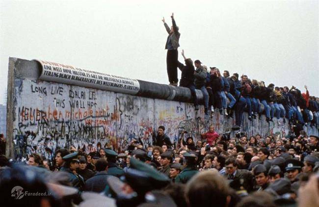 1989- سقوط دیوار برلین
یک مرد در حال خوشحالی بر روی دیوار برلین در روز 12 نوامبر؛ این دیوار چند روز قبل در آلمان تخریب‌شده بود.