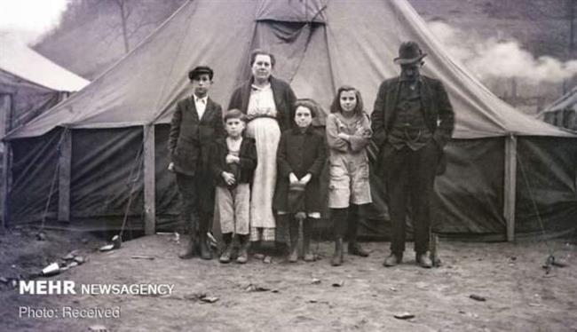 تصویر یک خانواده مقابل چادر خود در اردوگاه مهاجمان در رد ژاکت، ویرجینیای غربی، آمریکا
