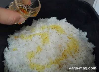 ریختن زعفران و روغن زیتون روی برنج 