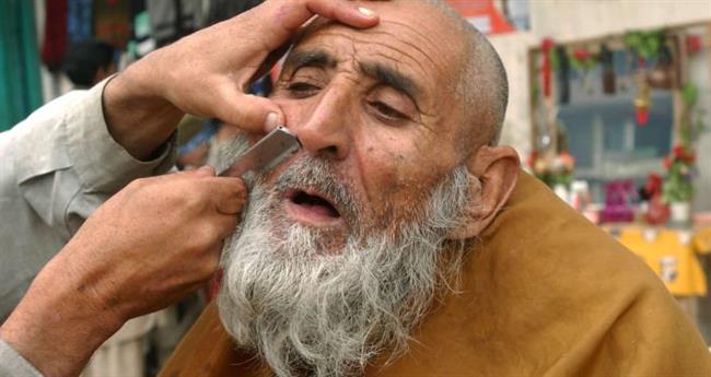 آرایشگر خیابانی در جلال آباد سال 2006 مشتری خود را اصلاح می کند
