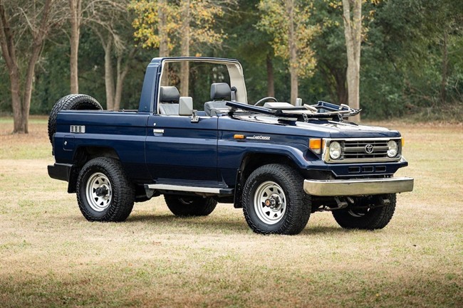 نمای تویوتا لندکروزر سری 70 مدل HZJ73 با بدنه کروک و شیشه جلوی تاشو در فضای باز.