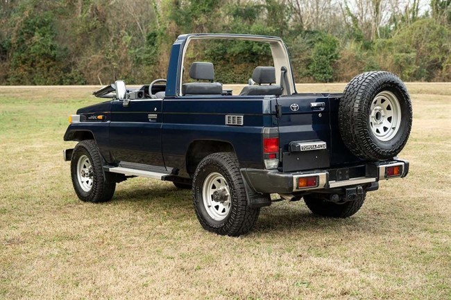 نمای تویوتا لندکروزر سری 70 مدل HZJ73 با بدنه کروک و شیشه جلوی تاشو در فضای باز.